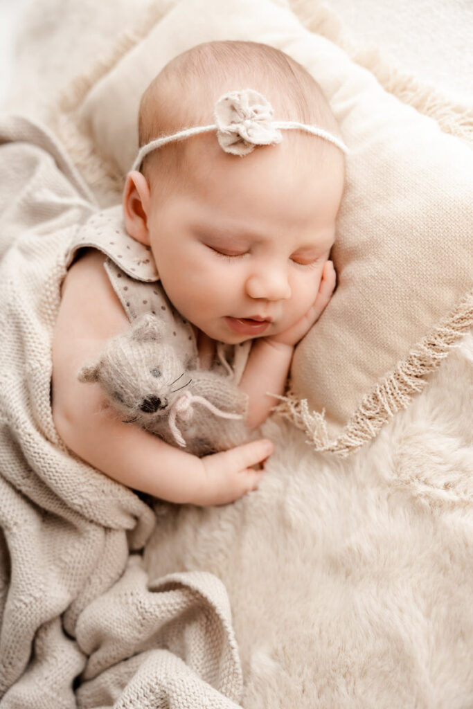 Newborn Baby mit Haarschleife und Katze