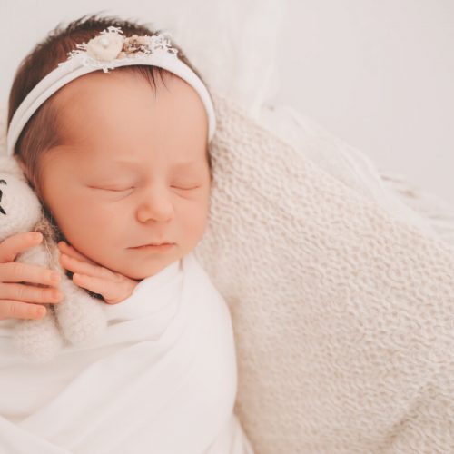 Baby Mädchen mit gestrickten Bär in der Hand