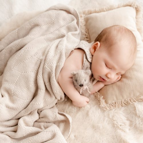 Baby mit Strickdecke zugedeckt, es schläft