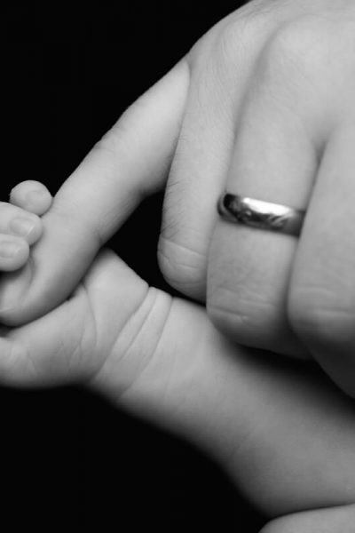 Babyhand in schwarz-weiss und der kleine Finger vom Papa