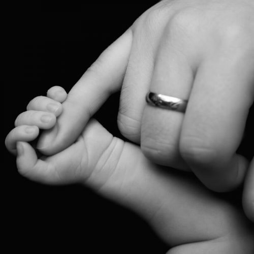 Babyhand in schwarz-weiss und der kleine Finger vom Papa