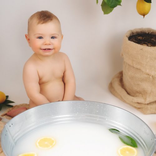 Ein Baby sitzt vor der Badewanne